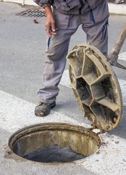 operator inspecting manhole