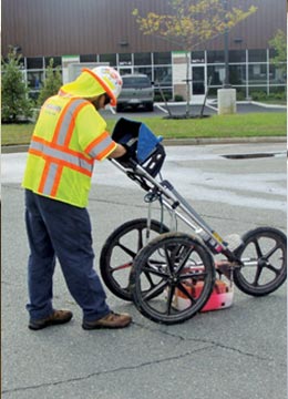 Engineer marking asphalt for subsurface utility location